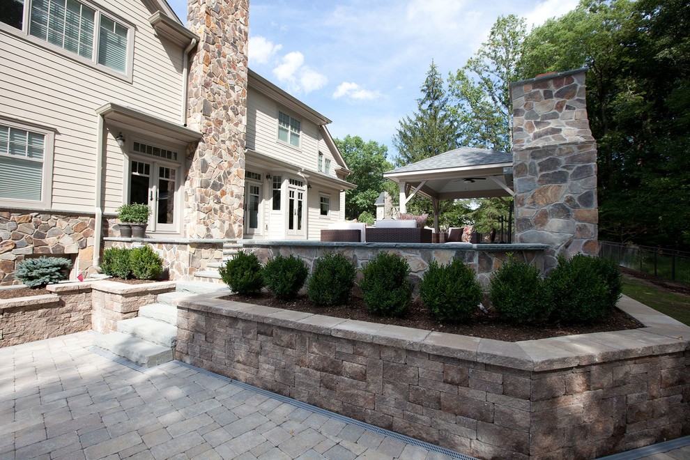 Raised patio with outdoor kitcen, fireplace and pergola Traditional