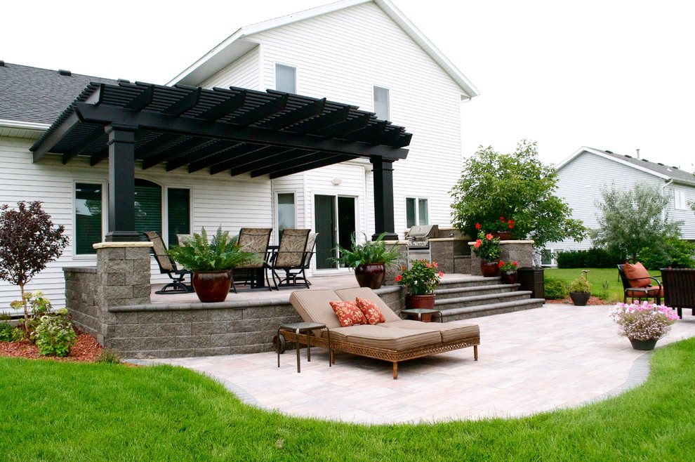 Example of a large trendy backyard concrete paver patio kitchen design in Other with a pergola