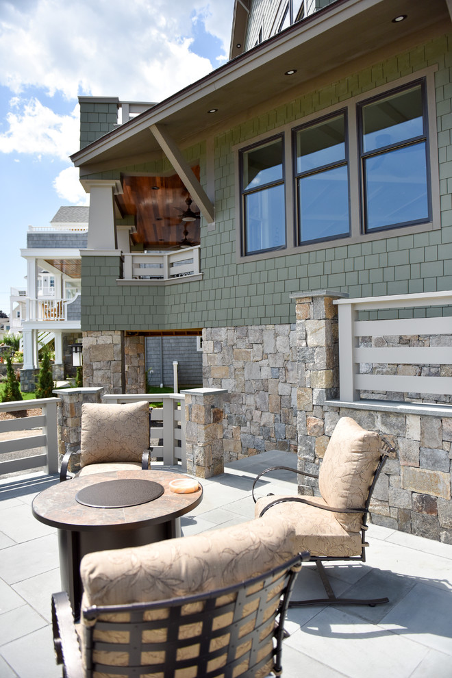 Imagen de patio de estilo americano de tamaño medio sin cubierta en patio delantero con brasero y adoquines de piedra natural