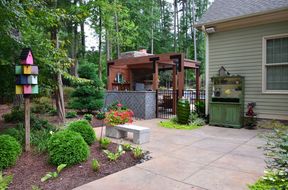 Diseño de patio tradicional de tamaño medio en patio trasero con suelo de hormigón estampado y cenador