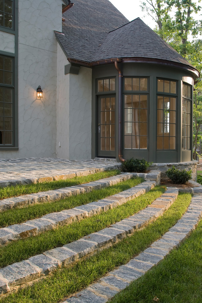 На фото: большой двор на заднем дворе в классическом стиле с покрытием из каменной брусчатки с