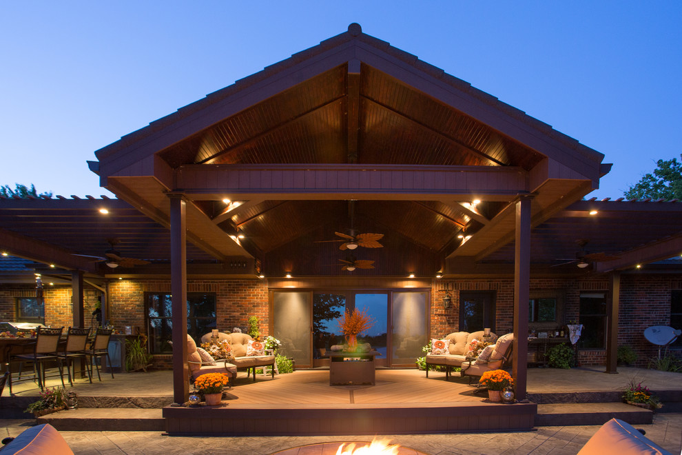 Inspiration for a large traditional back patio in Kansas City with an outdoor kitchen, stamped concrete and a pergola.