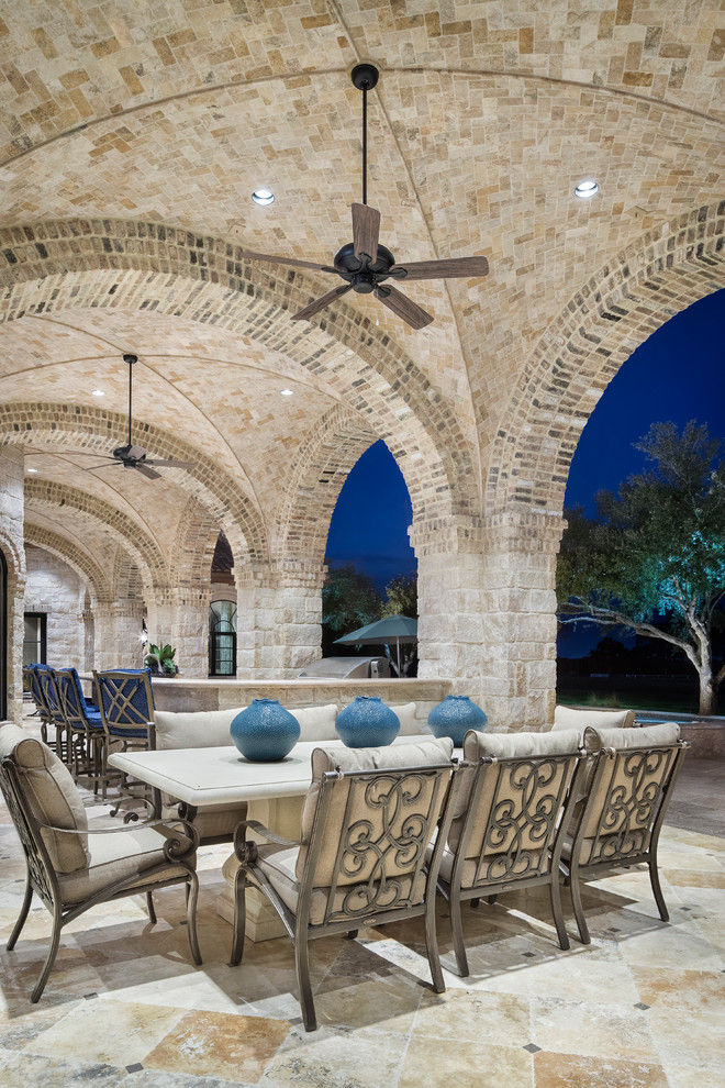 Inspiration for an expansive mediterranean back patio in Austin with a fire feature and a roof extension.