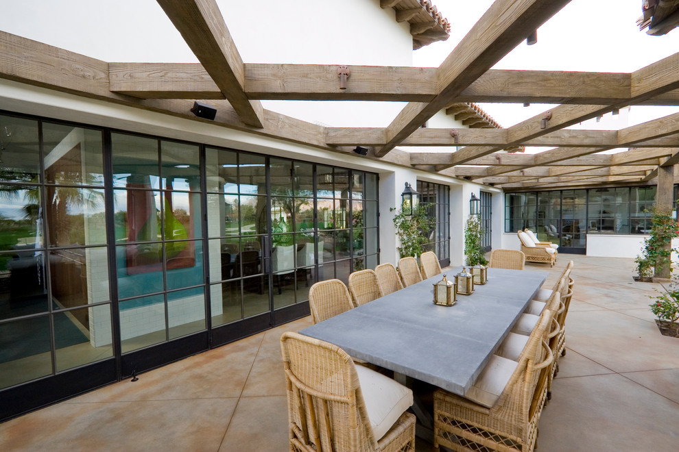 Inspiration for a huge mediterranean backyard concrete paver patio remodel in Santa Barbara with a pergola