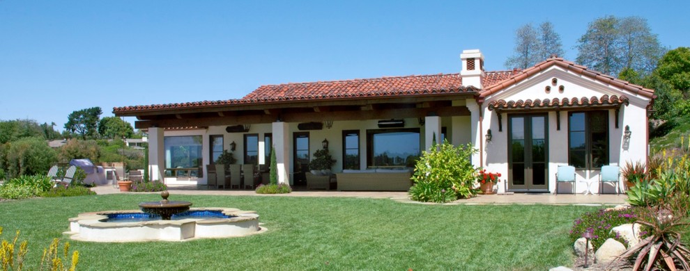 На фото: двор на заднем дворе в средиземноморском стиле с покрытием из бетонных плит и навесом