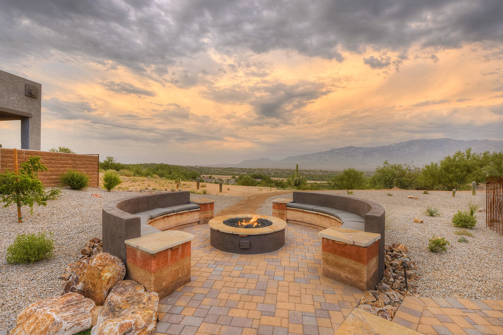 This is an example of a medium sized patio in Phoenix with concrete paving, a fire feature and no cover.