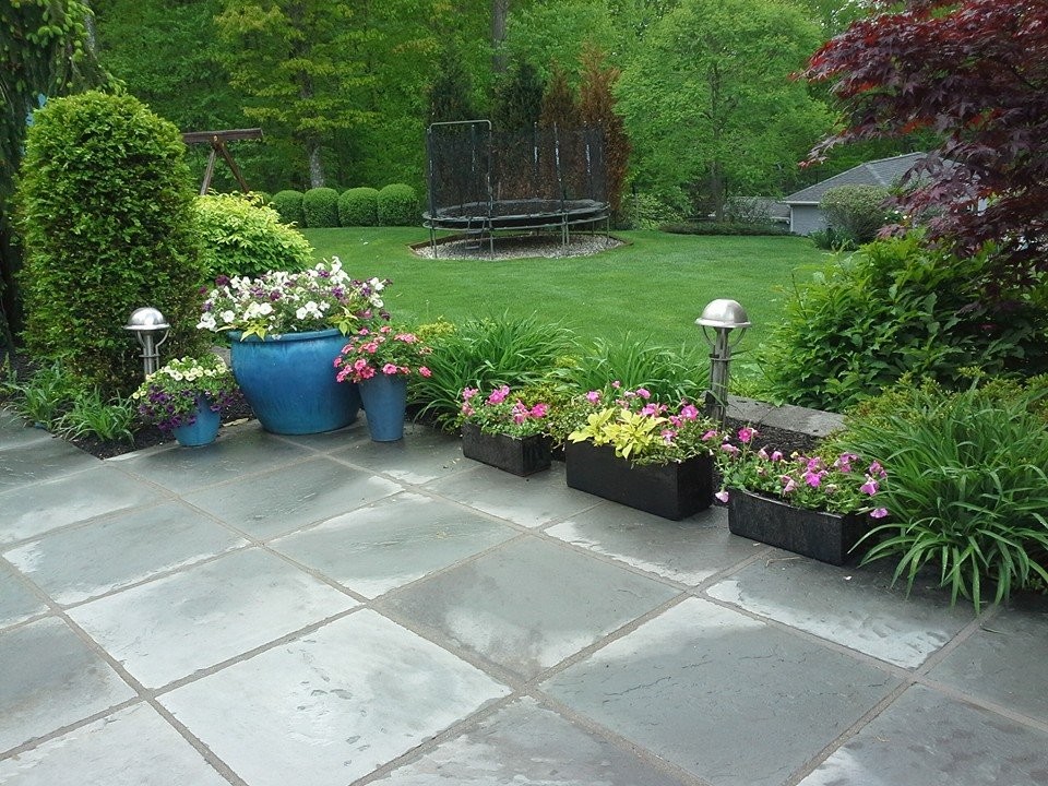 Esempio di un patio o portico design di medie dimensioni e dietro casa con un giardino in vaso, pavimentazioni in pietra naturale e nessuna copertura