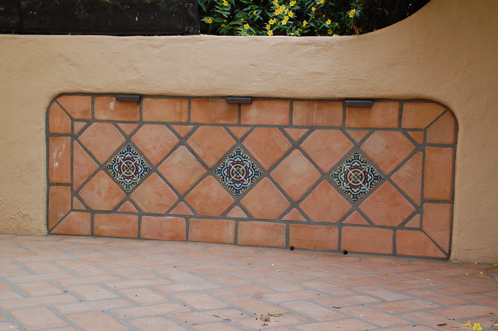 Imagen de patio mediterráneo grande sin cubierta en patio trasero con brasero y adoquines de ladrillo