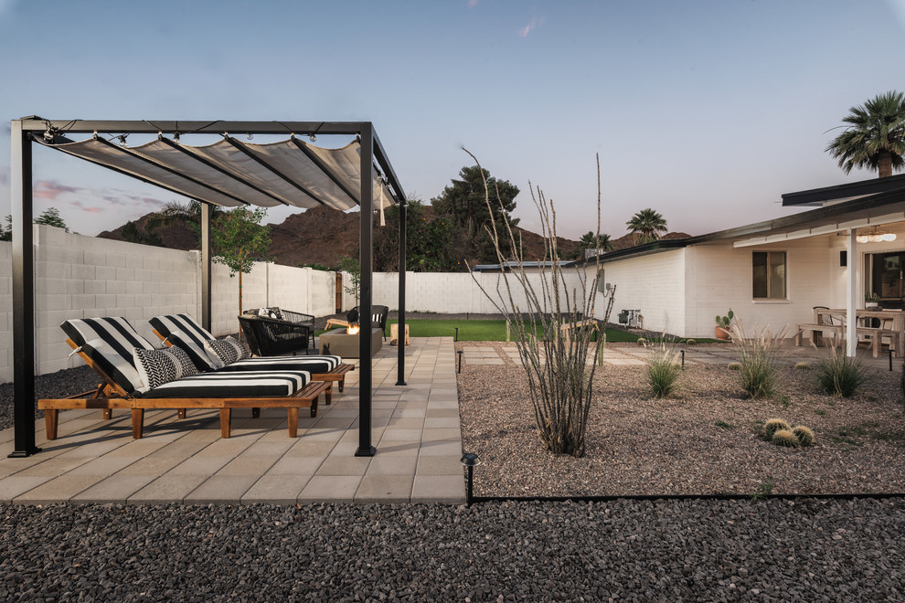 Medium sized contemporary back patio in Phoenix with a fire feature, concrete paving and an awning.