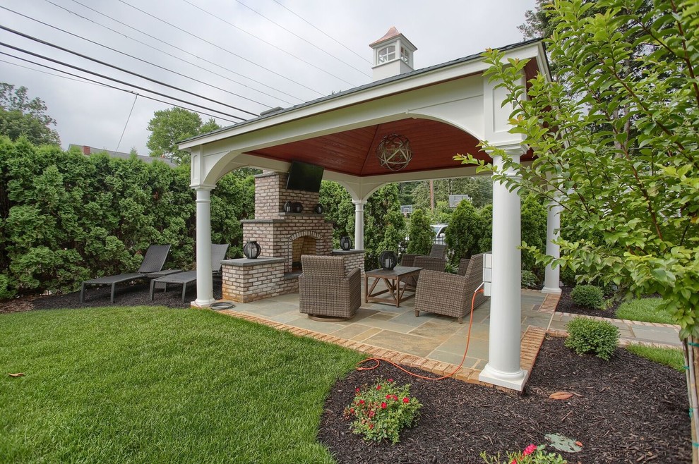 Example of a mid-sized transitional backyard stone patio design in Philadelphia with a fire pit and a gazebo
