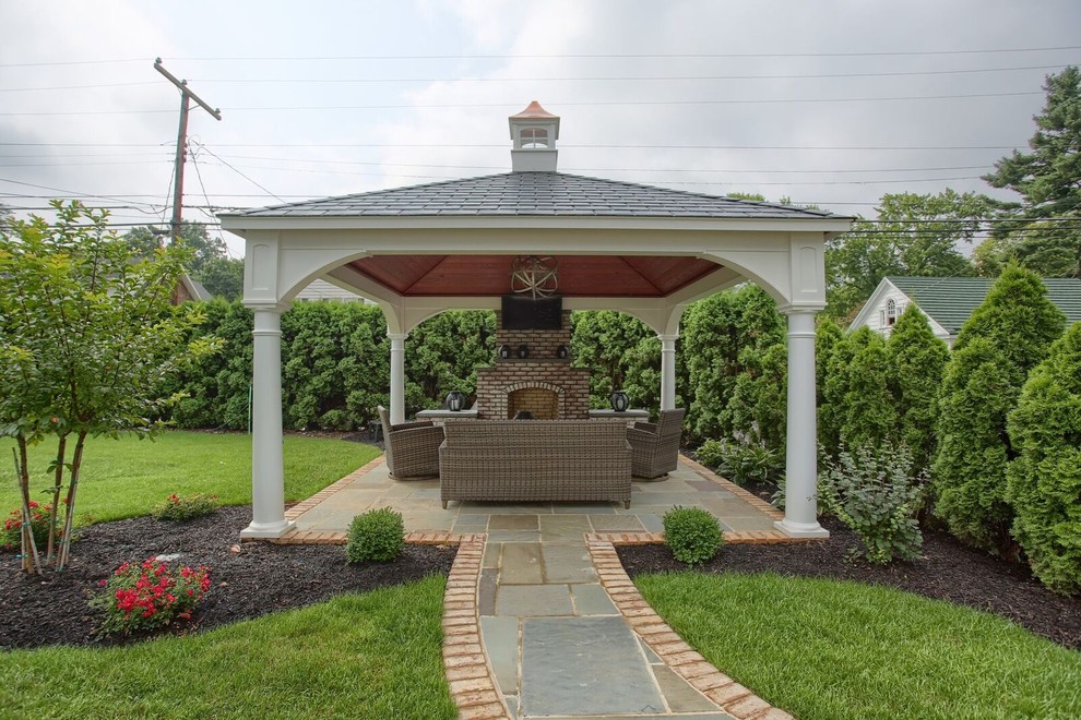 Esempio di un patio o portico classico di medie dimensioni e dietro casa con un focolare, pavimentazioni in pietra naturale e un gazebo o capanno
