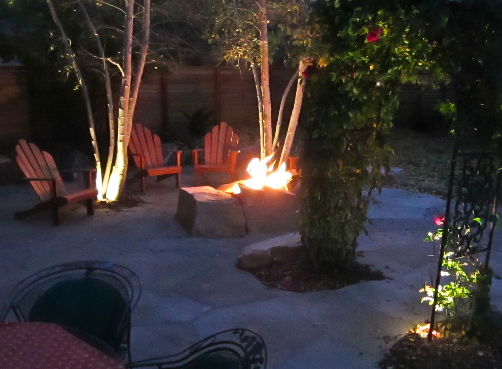 Photo of a large mediterranean back patio in Denver with a fire feature, natural stone paving and no cover.