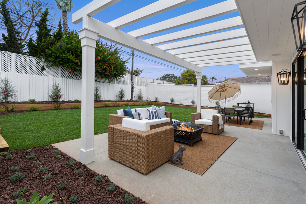 Ispirazione per un patio o portico classico dietro casa con un focolare, pavimentazioni in cemento e una pergola