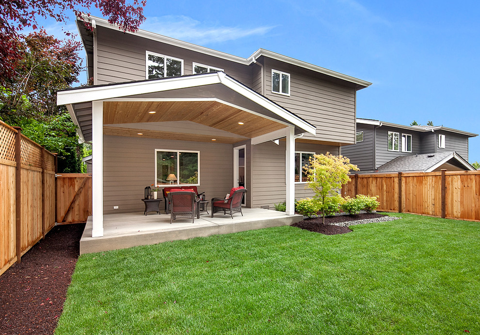 Photo of a traditional back patio in Seattle with concrete slabs and a roof extension.