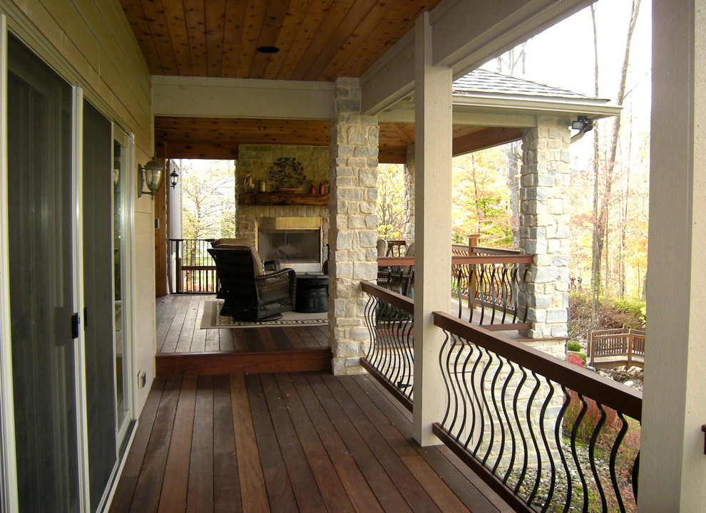 Esempio di un patio o portico chic dietro casa con un focolare, pedane e un tetto a sbalzo