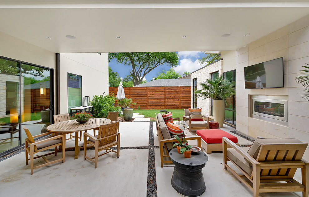 На фото: большой двор на заднем дворе в стиле модернизм с местом для костра и навесом с
