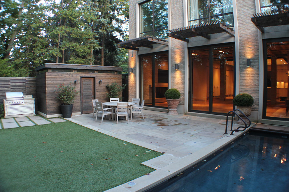 Design ideas for a contemporary patio in Toronto with an awning and a bbq area.