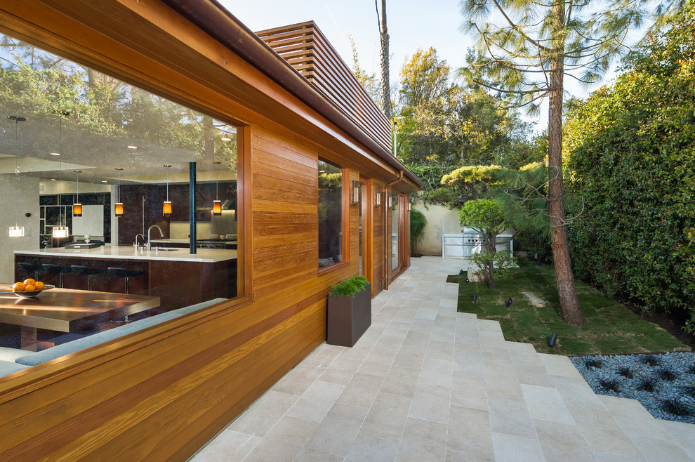 Idee per un patio o portico minimalista di medie dimensioni e dietro casa con piastrelle e nessuna copertura