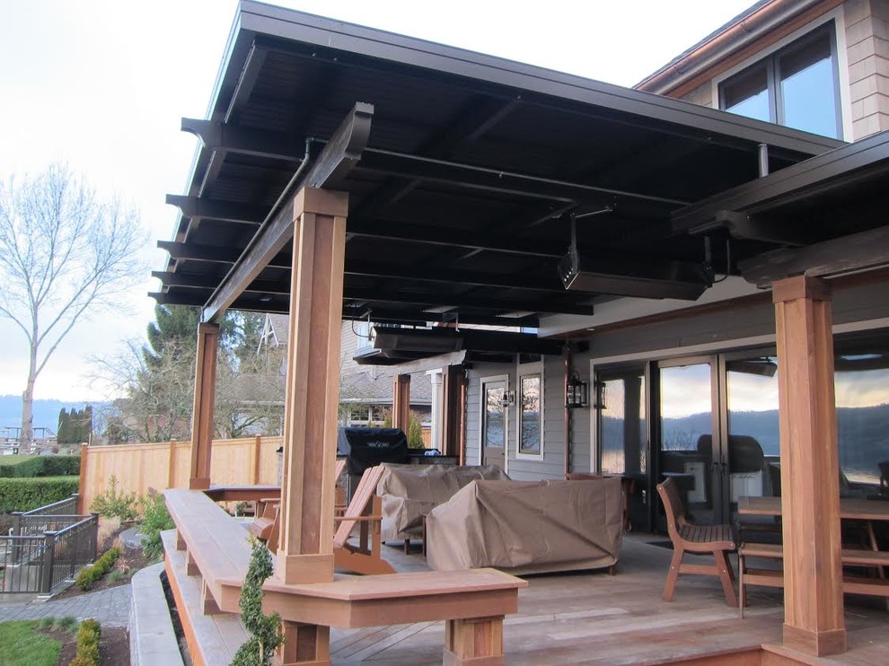 Idee per un patio o portico design di medie dimensioni e dietro casa con pedane e un tetto a sbalzo
