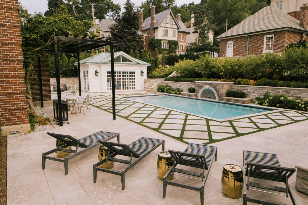 Large classic back patio in Toronto with natural stone paving and a pergola.