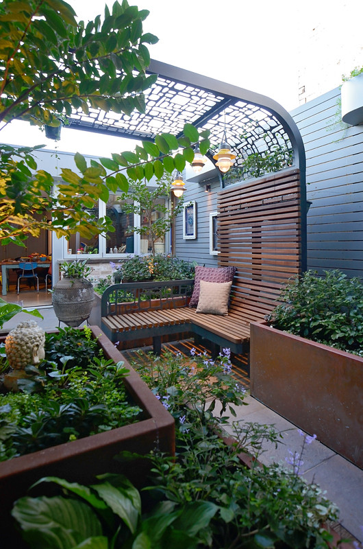Foto di un piccolo patio o portico contemporaneo dietro casa con un giardino in vaso, pedane e una pergola