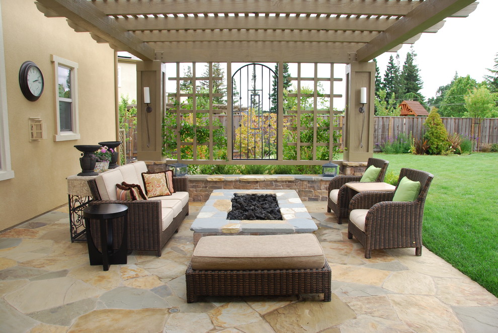 Inspiration for a large mediterranean backyard stone patio remodel in San Francisco with a fire pit and a pergola