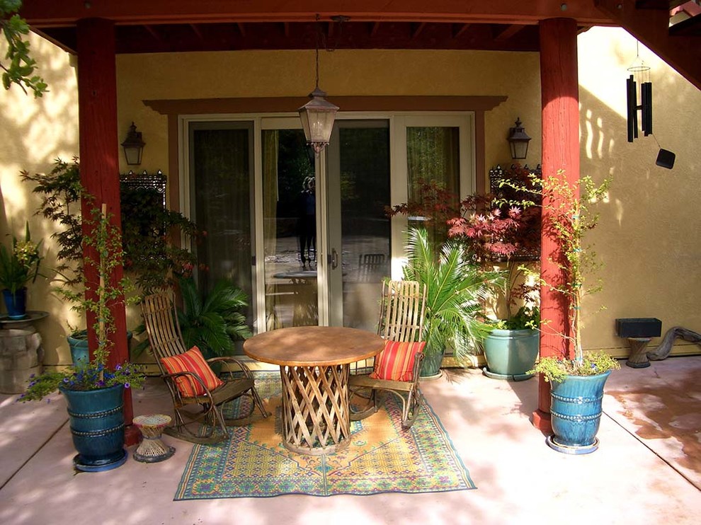 На фото: двор среднего размера на заднем дворе в восточном стиле с фонтаном, покрытием из бетонных плит и навесом с