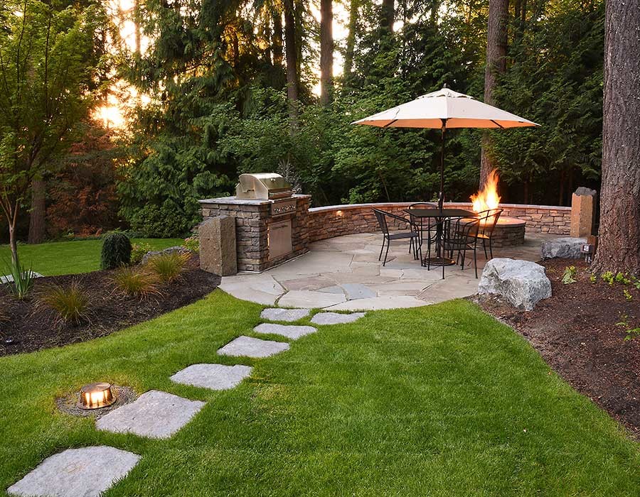 Example of a large classic backyard stone patio design in Seattle with a fire pit