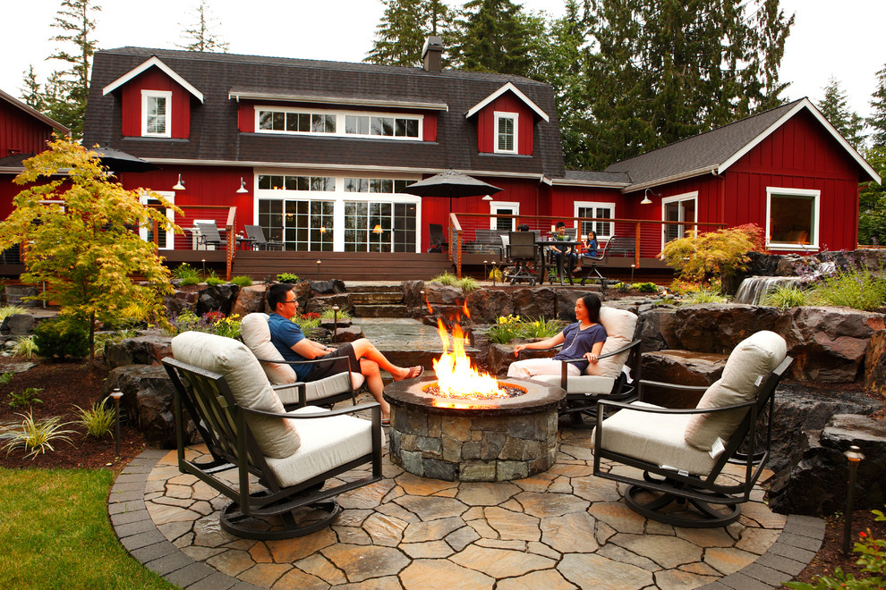 Uriger Patio hinter dem Haus mit Feuerstelle und Natursteinplatten in Seattle