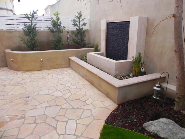 Kleiner, Unbedeckter Moderner Patio hinter dem Haus mit Wasserspiel und Natursteinplatten in Los Angeles