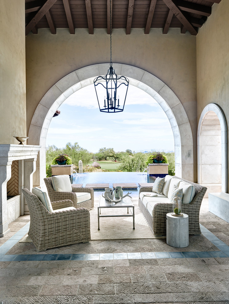 Immagine di un patio o portico mediterraneo con un caminetto