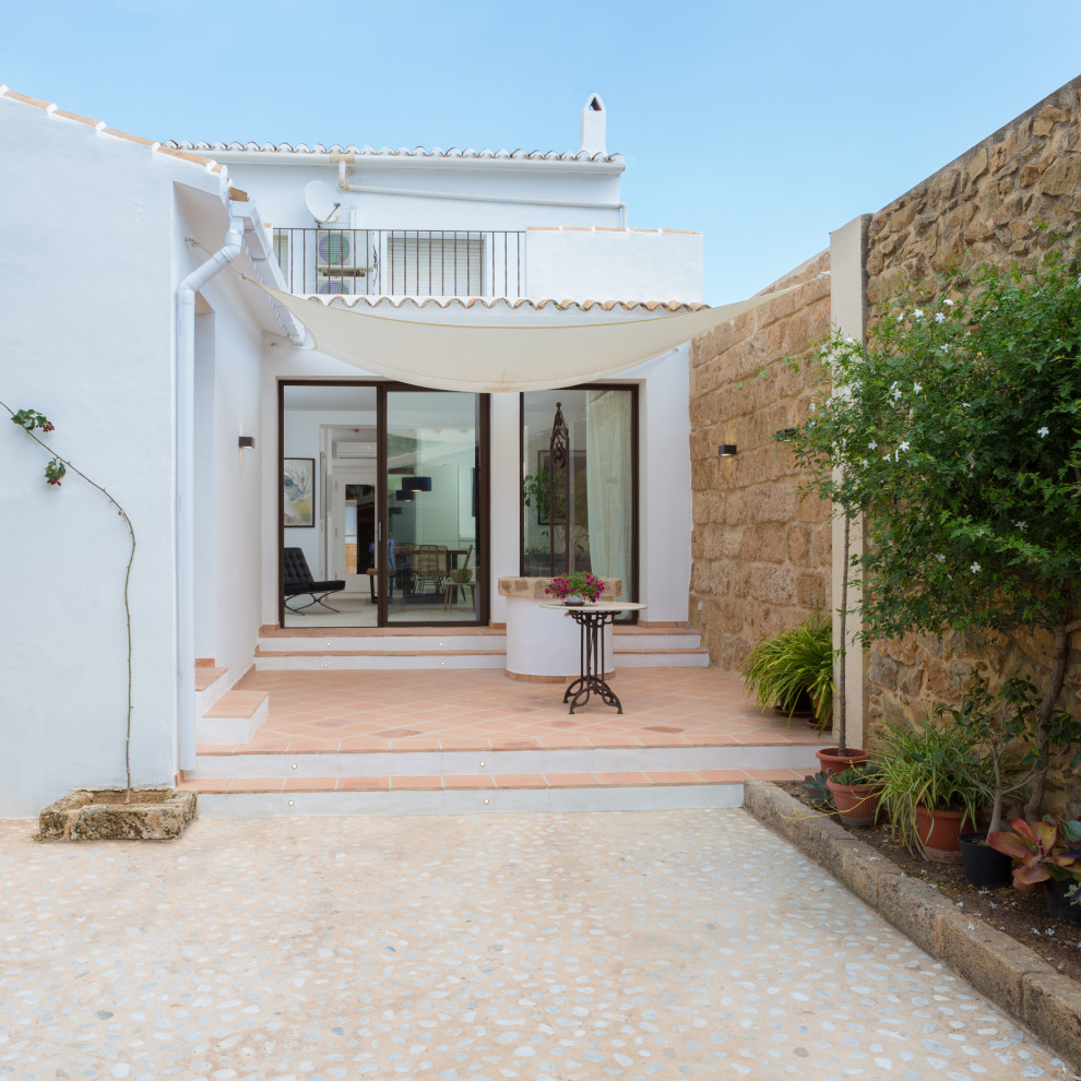 Mediterranean courtyard patio in Alicante-Costa Blanca with tiled flooring and an awning.