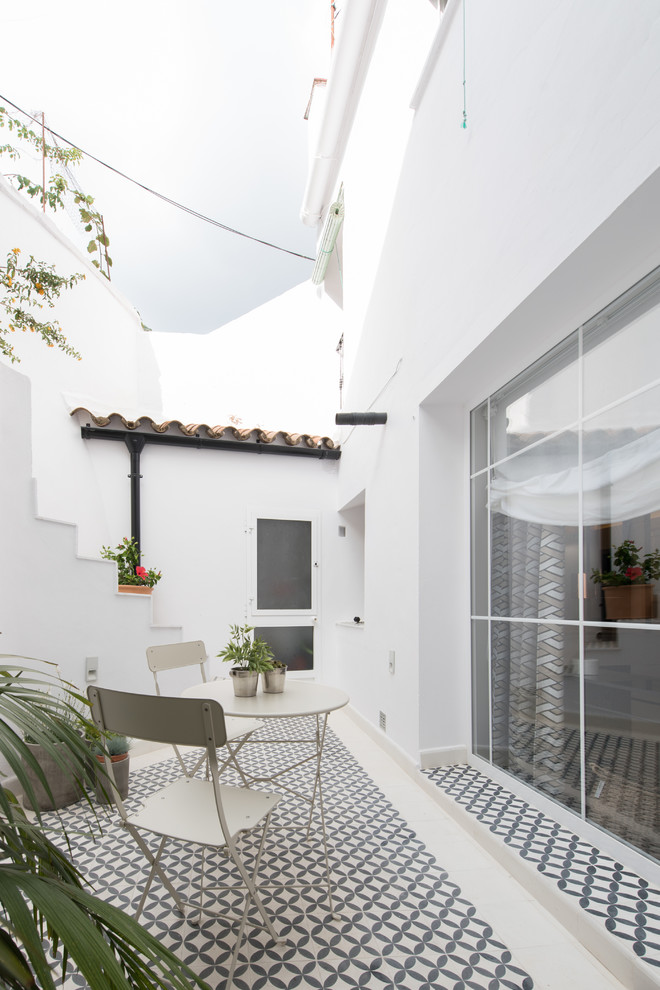 На фото: двор на боковом дворе в средиземноморском стиле без защиты от солнца