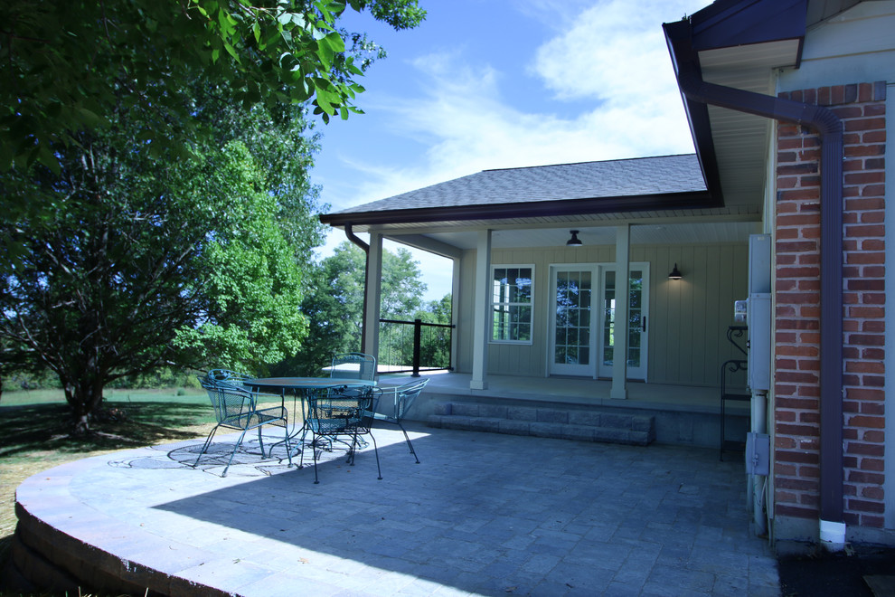 Immagine di un patio o portico tradizionale di medie dimensioni e dietro casa con un tetto a sbalzo
