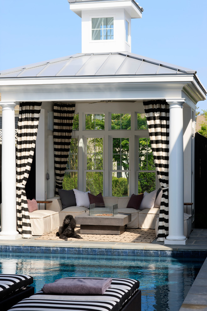 This is an example of a beach style back patio in DC Metro with tiled flooring, a gazebo and a fire feature.