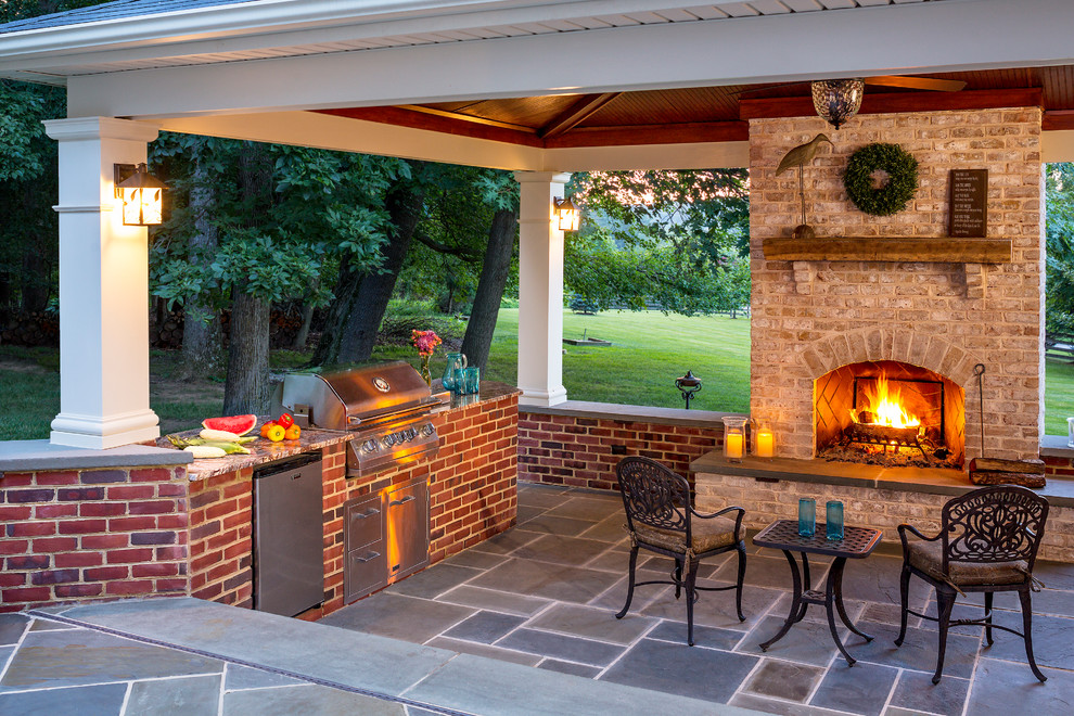 Example of a trendy backyard stone patio kitchen design in Baltimore with a gazebo