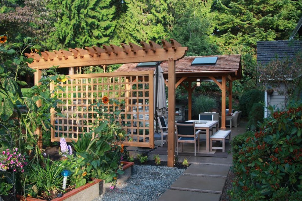 Modelo de patio tradicional renovado grande en patio trasero con cocina exterior, losas de hormigón y cenador