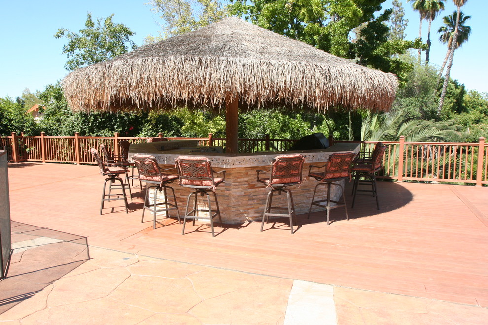 Immagine di un grande patio o portico tropicale dietro casa con pedane e un gazebo o capanno