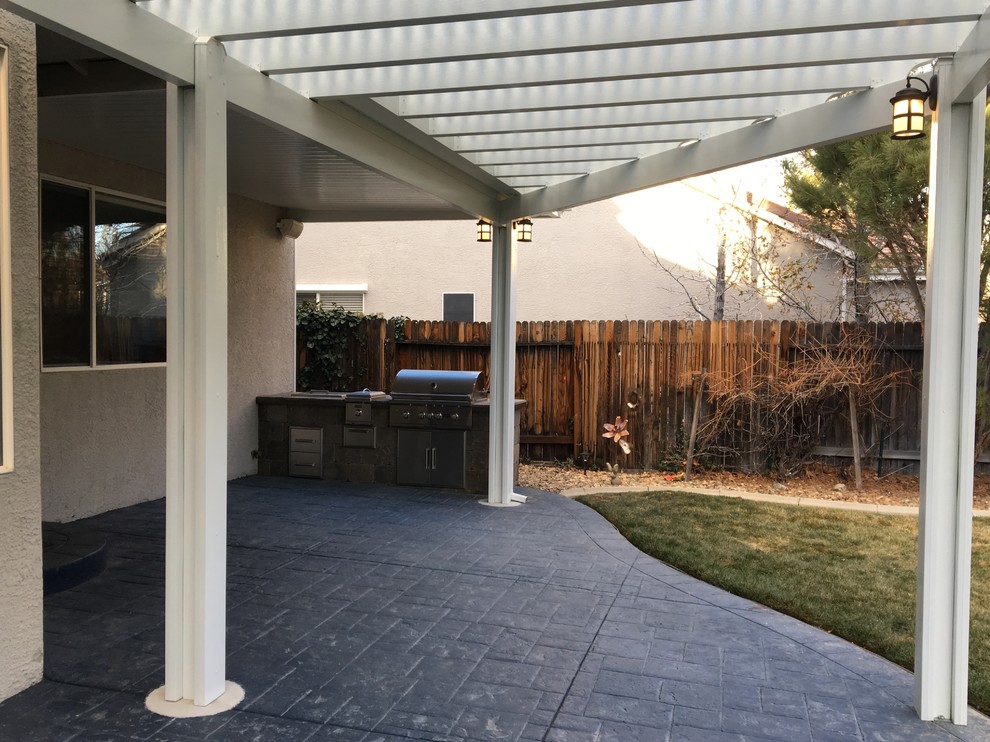 Foto de patio tradicional renovado de tamaño medio en patio trasero con cocina exterior, suelo de hormigón estampado y pérgola