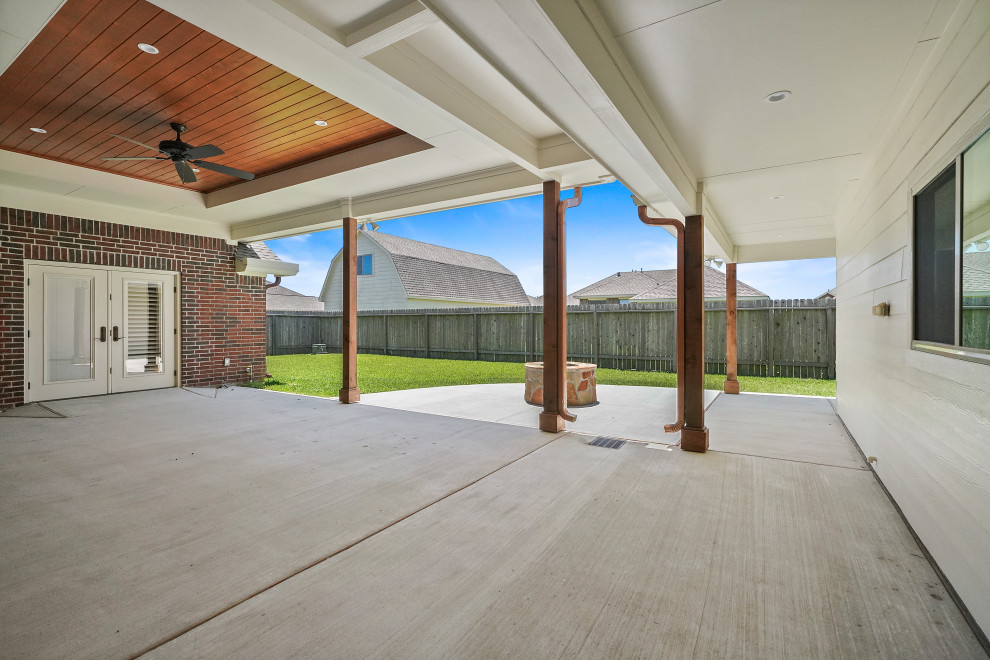 Patio - mid-sized contemporary backyard stone patio idea in Houston with a fire pit and a roof extension