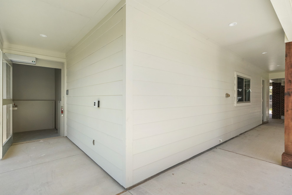 Réalisation d'une terrasse arrière design de taille moyenne avec un foyer extérieur, des pavés en pierre naturelle et une extension de toiture.