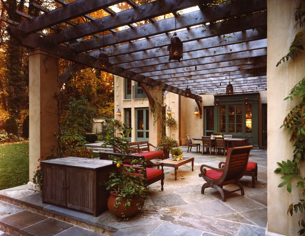 Foto de patio tradicional con pérgola y adoquines de piedra natural