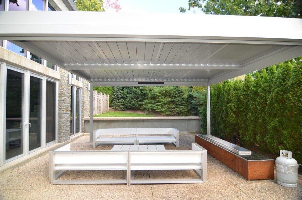 Foto di un patio o portico minimal di medie dimensioni e dietro casa con graniglia di granito e una pergola