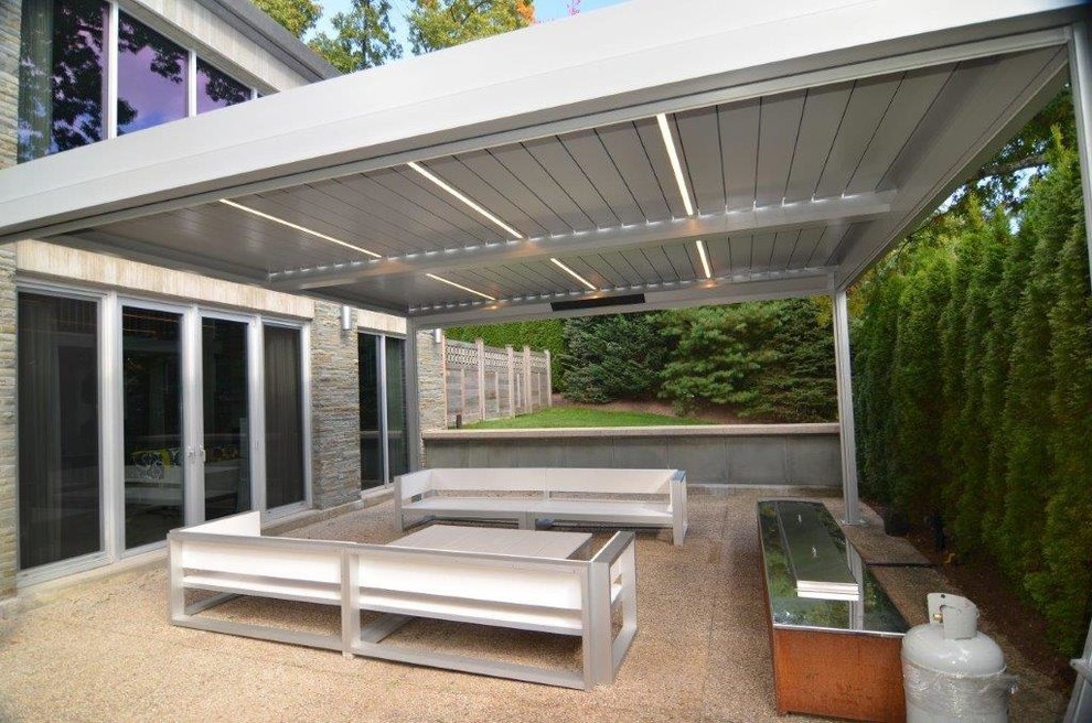 Immagine di un patio o portico contemporaneo di medie dimensioni e dietro casa con graniglia di granito e una pergola