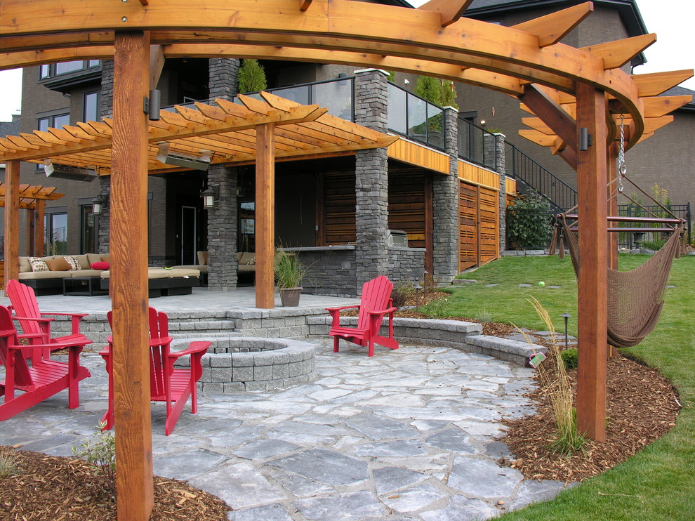 Esempio di un ampio patio o portico classico dietro casa con un focolare, pavimentazioni in pietra naturale e una pergola