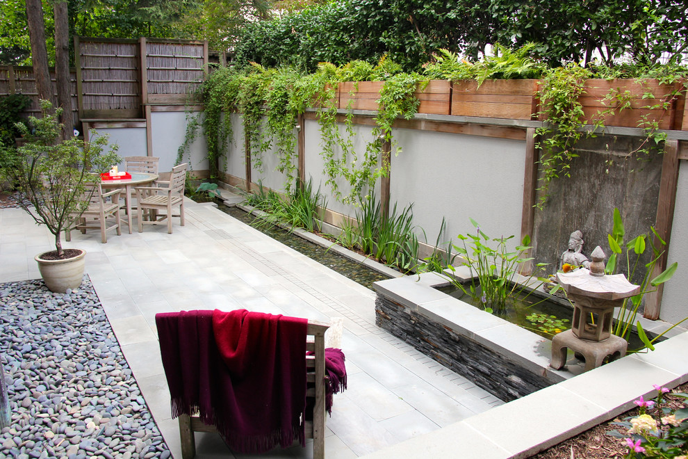 Réalisation d'une petite terrasse asiatique avec un point d'eau, une cour, des pavés en pierre naturelle et aucune couverture.