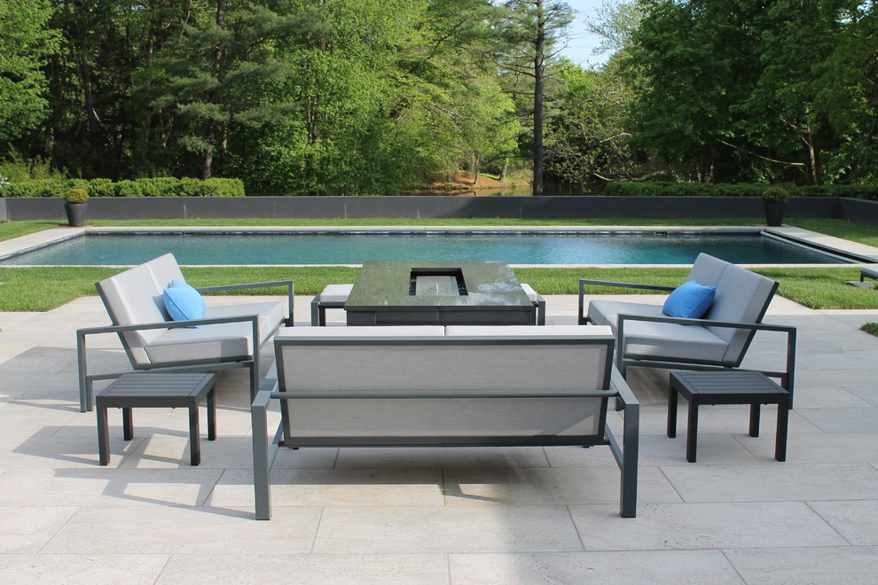 Photo of a contemporary patio in New York with a fire feature and concrete slabs.
