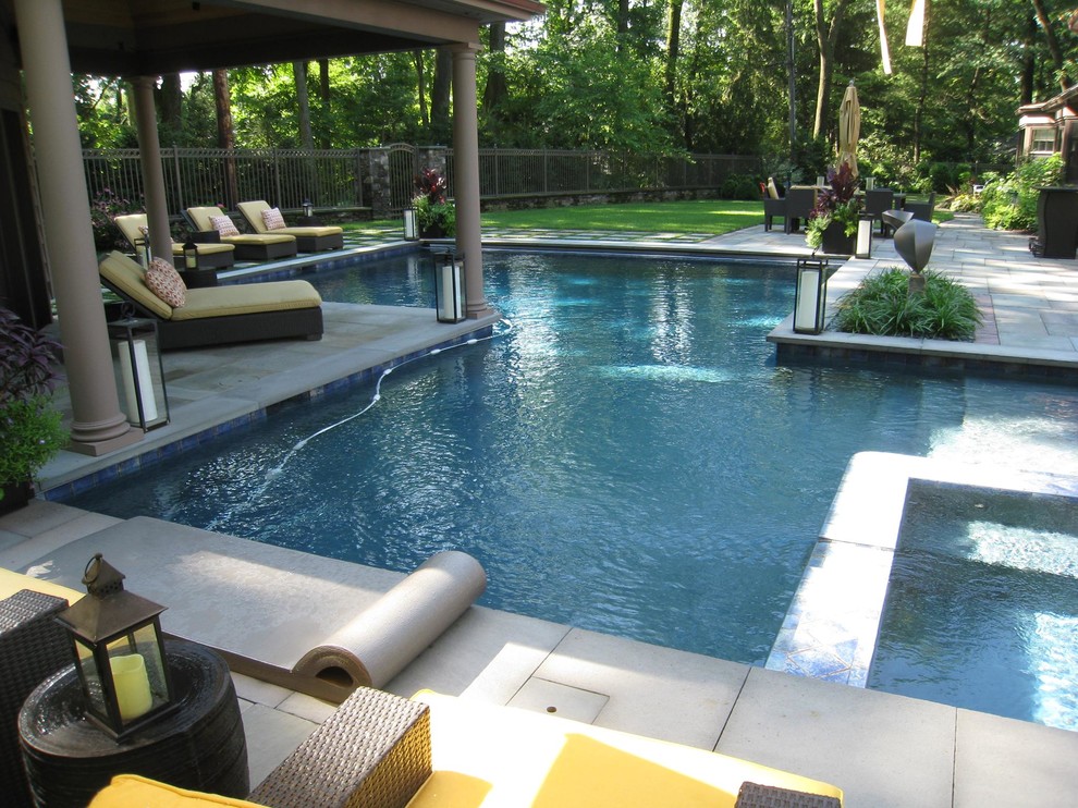 Modelo de piscina tradicional de tamaño medio en patio trasero con adoquines de ladrillo