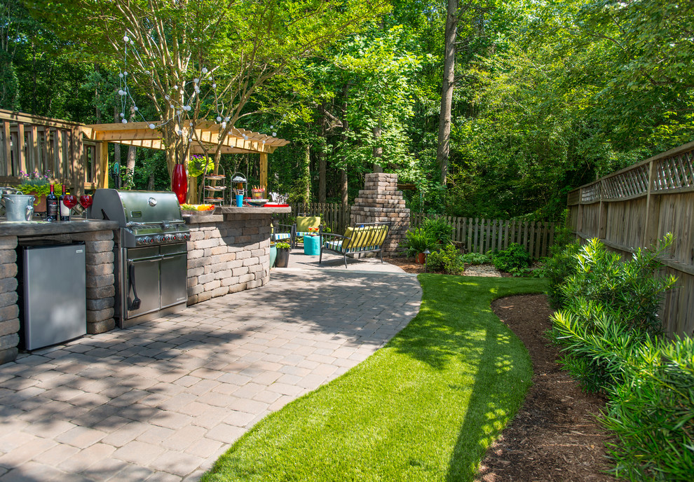 Diseño de patio clásico de tamaño medio en patio trasero con cocina exterior, adoquines de ladrillo y pérgola
