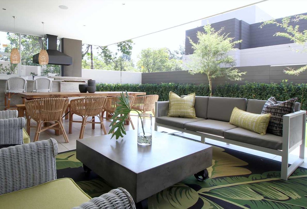 Aménagement d'une terrasse arrière exotique avec une cuisine d'été, du carrelage et une extension de toiture.